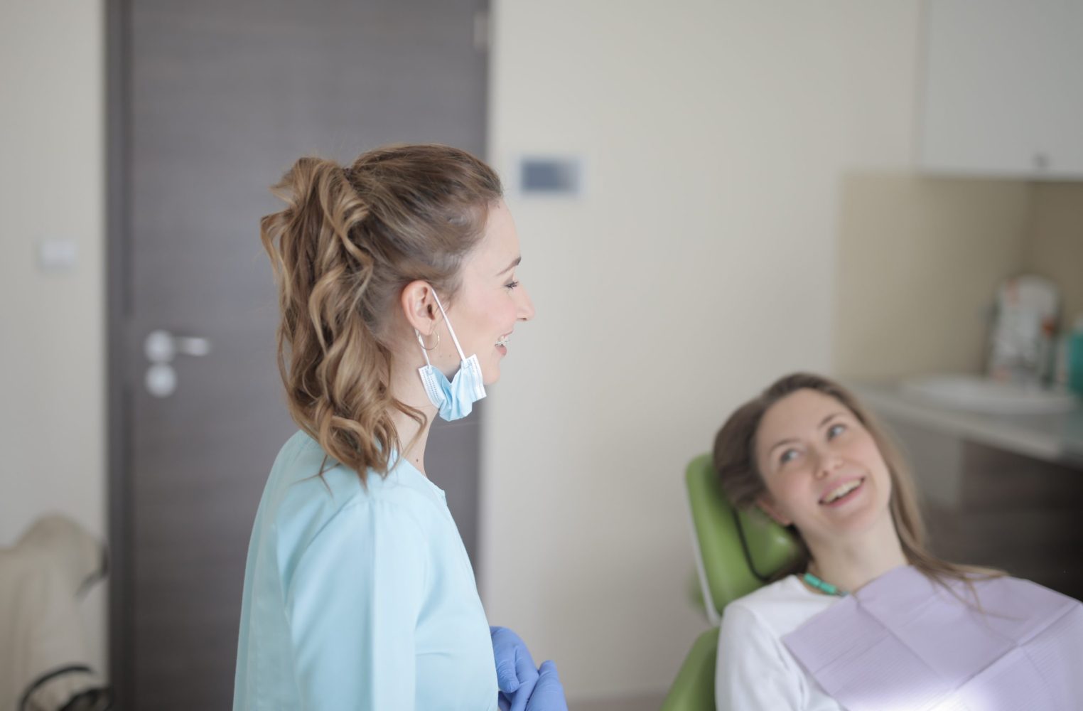Une patiente heureuse montrant son sourire après une gingivectomie, avec son dentiste