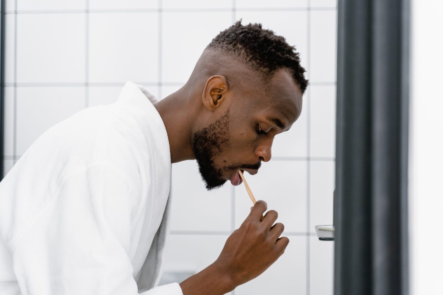 Un homme prend soin de sa santé bucco-dentaire en brossant ses dents