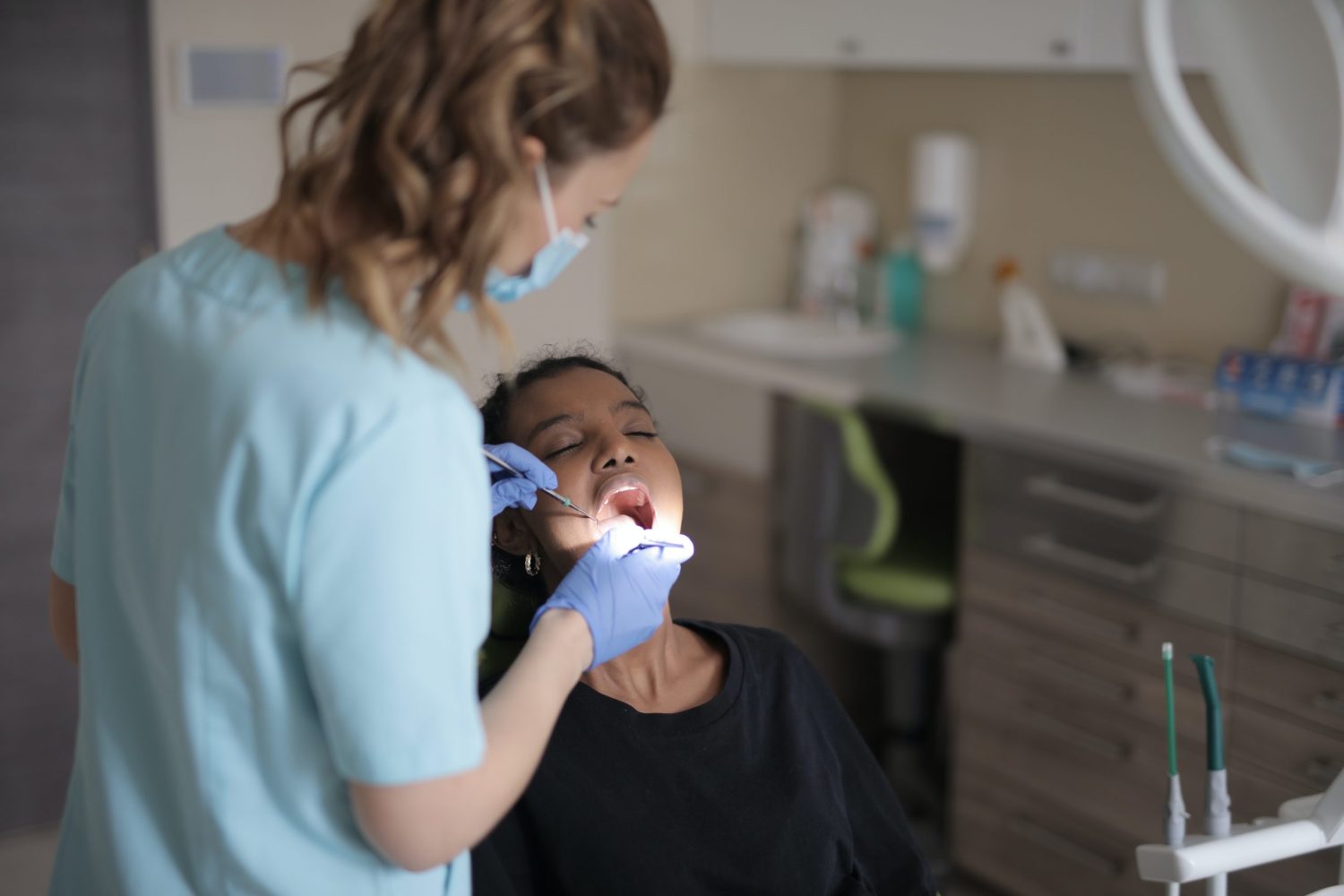 Image d'un dentiste en train d'extraire une dent chez un patient lors d'une intervention chirurgicale
